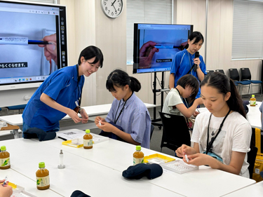 社員とともにボールペンの組み立てを体験の画像